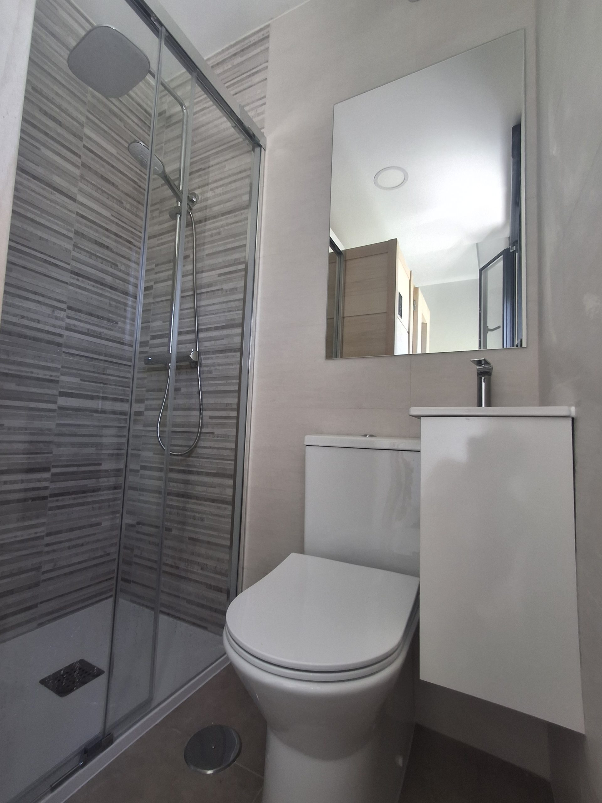 Baño reformado en Loeches con mampara de cristal y lavabo compacto