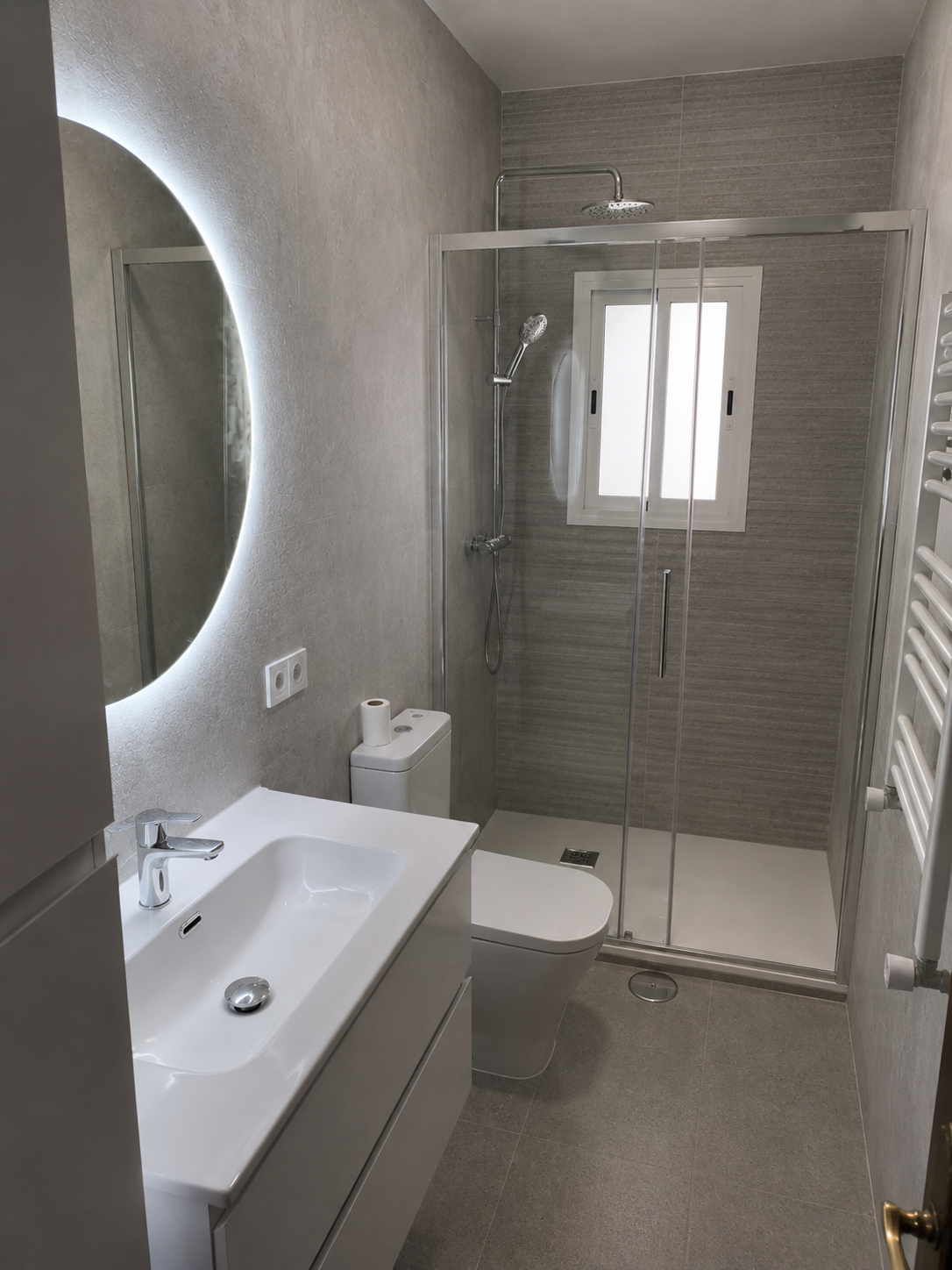 Vista de baño reformado en Carabanchel con acabados grises