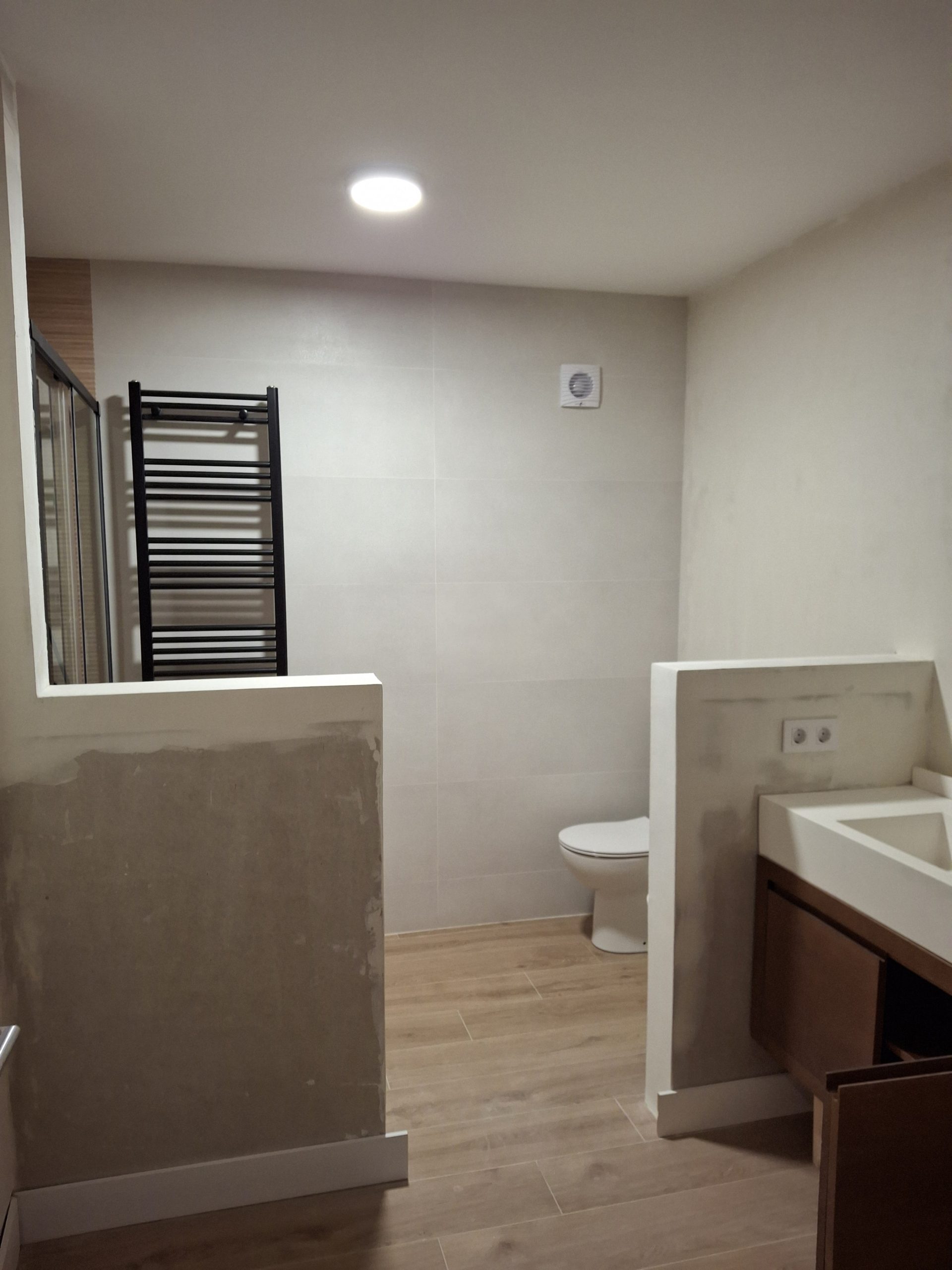 Acceso al baño reformado desde zona de habitación en Majadahonda