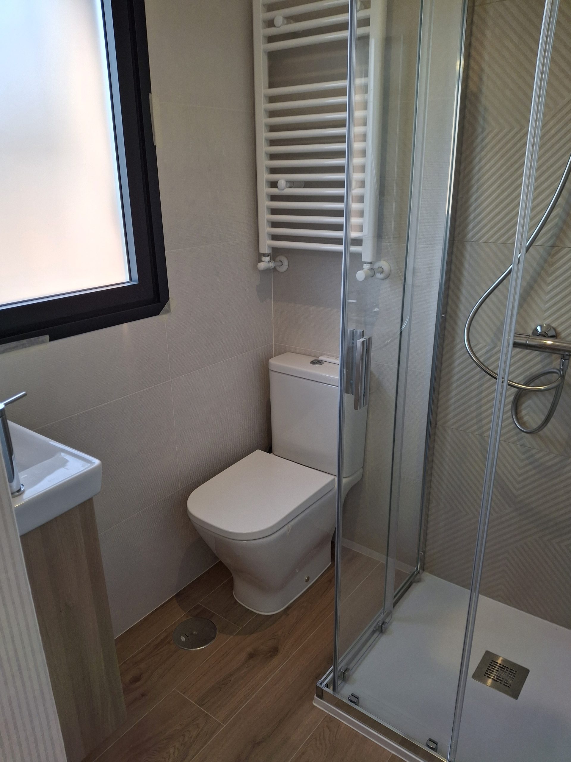 Zona de inodoro y bidé en baño reformado en Majadahonda
